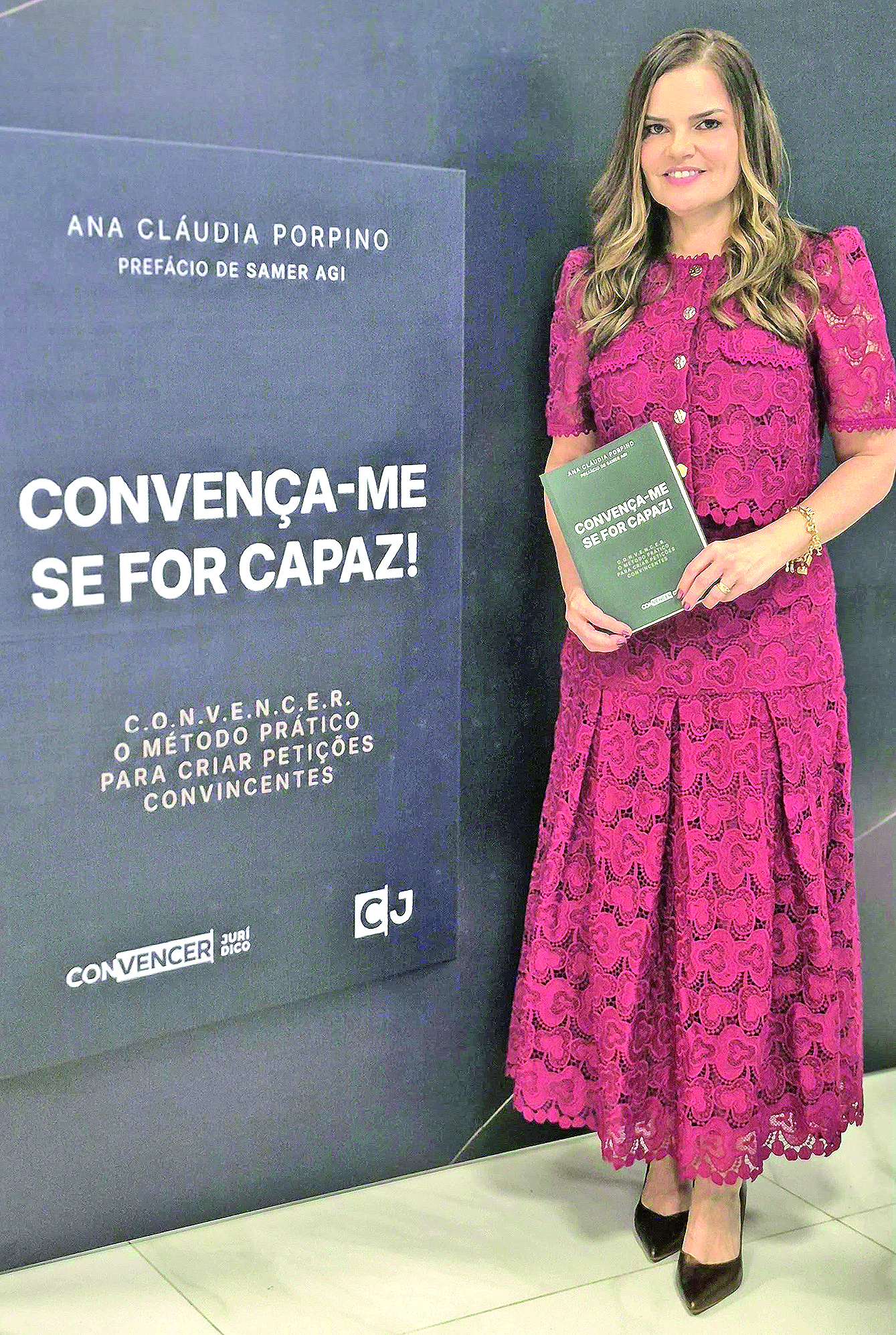 Ana Claudia Porpino segura seu livro diante do painel do lançamento