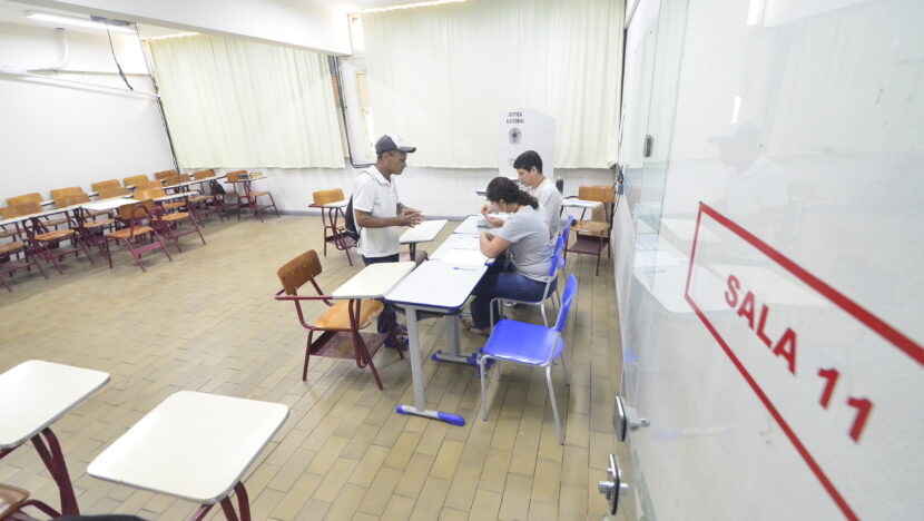 Eleitor é atendido por mesários em uma sala de votação