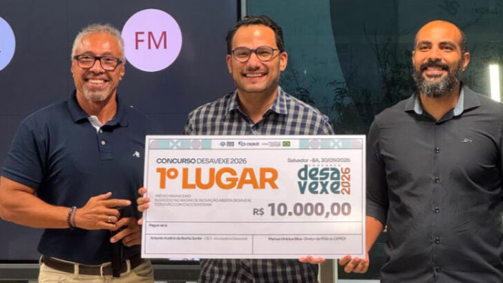 Três homens apresentam o prêmio de primeiro lugar do Concurso Desavexe 2026