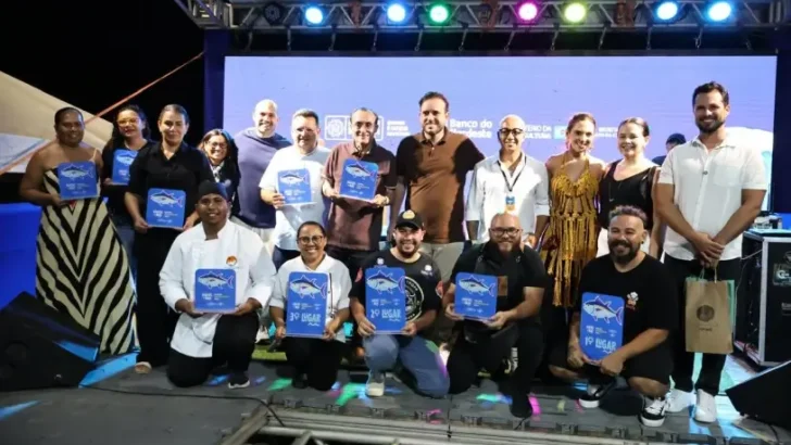 Participantes do Festival Ventos e Mar posam no palco com troféus da disputa gastronômica em Areia Branca