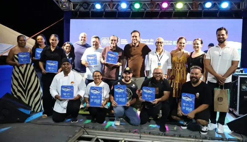 Participantes do Festival Ventos e Mar posam no palco com troféus da disputa gastronômica em Areia Branca