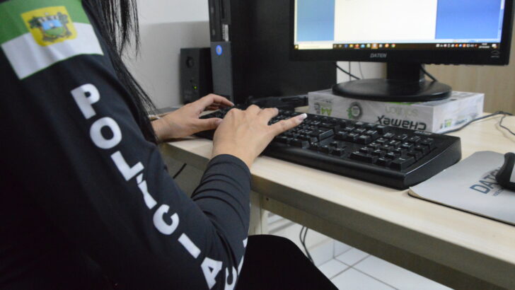 Policial civil trabalha diante de computador