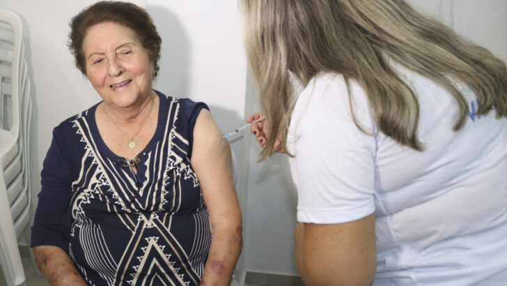 Profissional de saúde aplica vacina em uma mulher