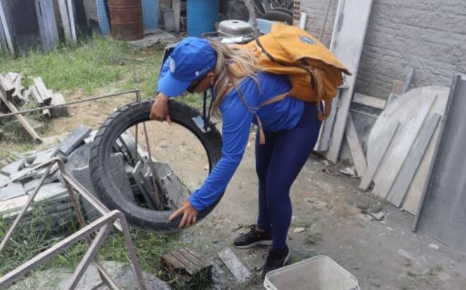 Agente de saúde inspeciona área externa durante ação de combate às arboviroses em Natal