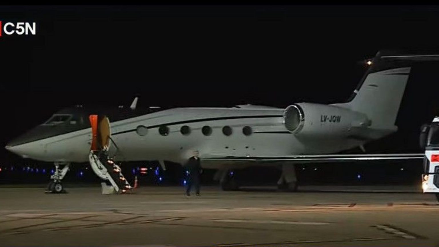 Avião particular branco de matrícula LV-JQW estacionado à noite, com escada de embarque aberta