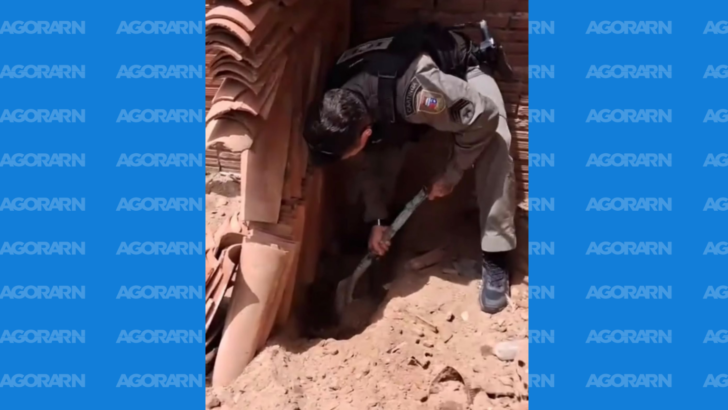 Policial faz buscas junto a um muro durante ação para localizar objetos furtados de túmulos em Parelhas