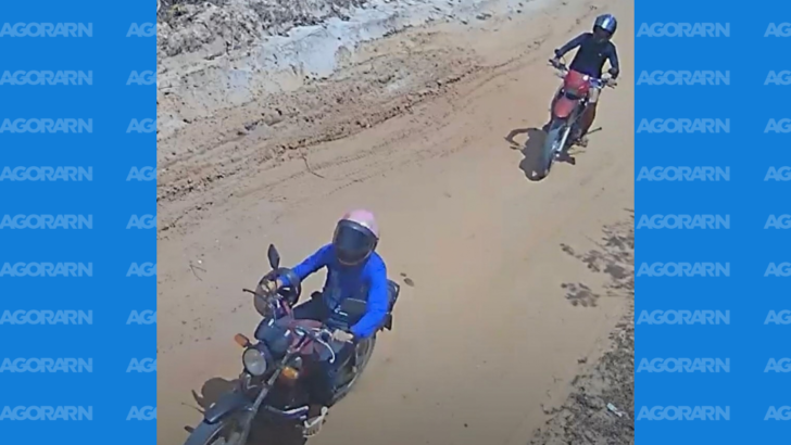 Imagem de câmera de segurança mostra dois motociclistas circulando por uma via não pavimentada