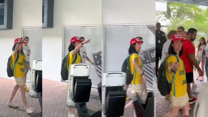 Sequência de imagens de mulher com camisa amarela e boné vermelho, erguendo o braço direito enquanto atravessa o pátio de uma escola