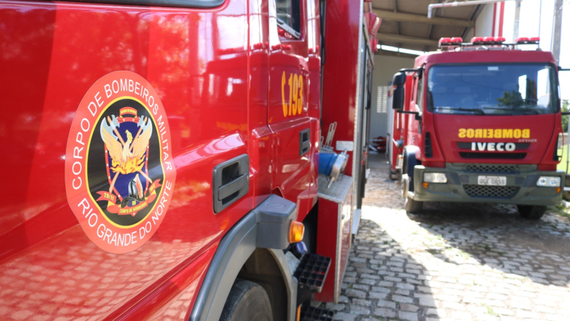 Dois caminhões vermelhos do Corpo de Bombeiros do RN estacionados, com o brasão da corporação em destaque no veículo à esquerda
