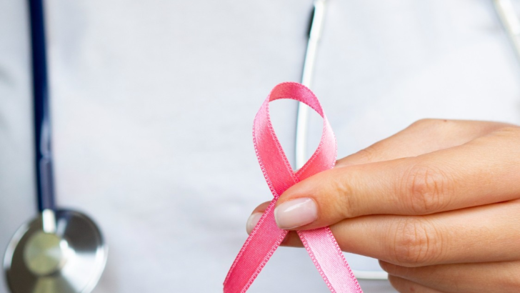 Profissional de saúde segura laço rosa, símbolo da prevenção ao câncer de mama