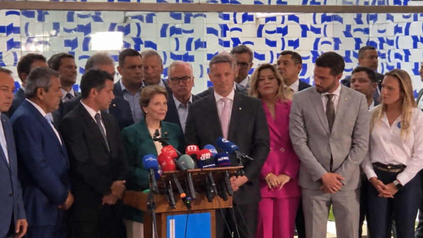 Lideranças do União Brasil e do PP reunidas diante de microfones durante coletiva de imprensa.