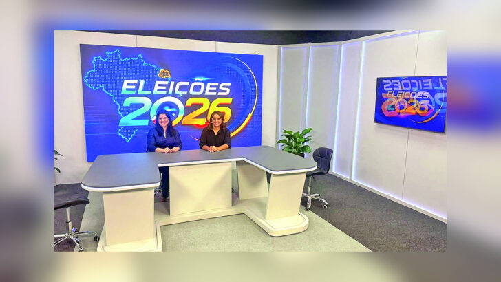 Apresentadoras da TV Câmara Natal em bancada diante de painéis das eleições de 2026