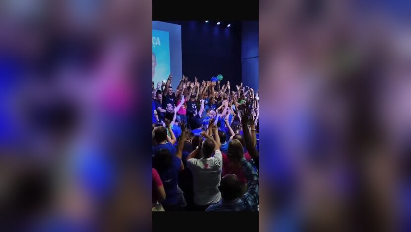 Participantes levantam os braços durante reunião política em Natal