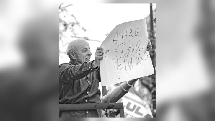 Presidente Lula segura cartaz com cobrança a Flávio Bolsonaro em Porto Alegre