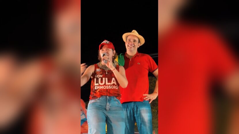 Isolda Dantas fala ao microfone ao lado de Cadu de Lula durante ato em Mossoró