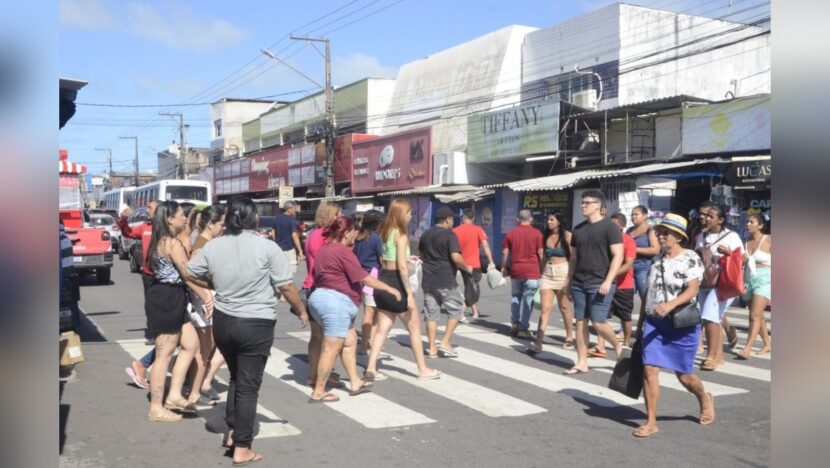 Pedestres atravessam rua na região comercial do bairro Alecrim em Natal