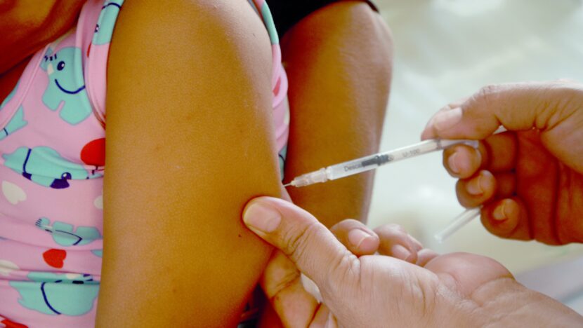 Profissional aplica vacina no braço de uma criança