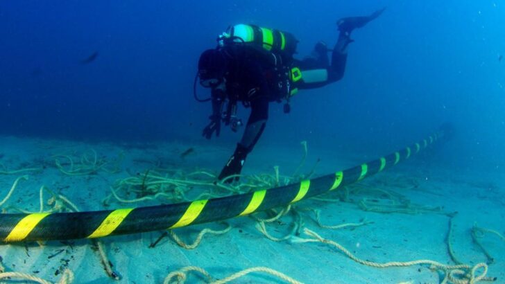 Mergulhador próximo a cabo submarino de telecomunicações