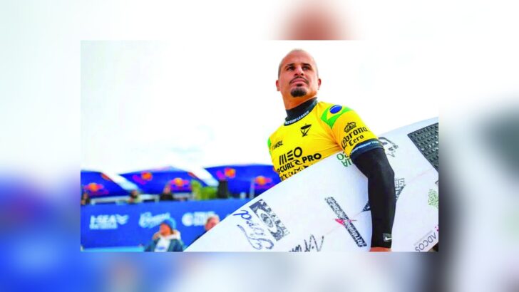 Ítalo Ferreira segura uma prancha e veste a lycra amarela na etapa de Peniche
