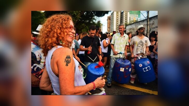 Participantes do Pau e Lata tocam tambores e instrumentos de percussão ao ar livre