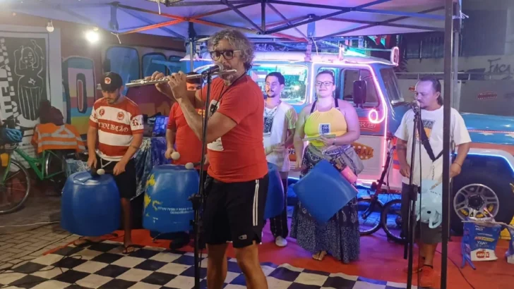 Integrantes do Pau e Lata tocam flauta, saxofone e tambores feitos de recipientes reaproveitados