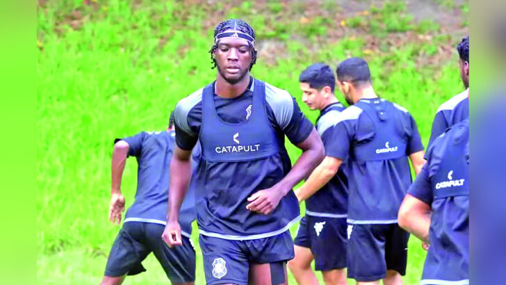Darlan Santos, com roupa de treino escura e faixa na cabeça, participa de atividade no gramado