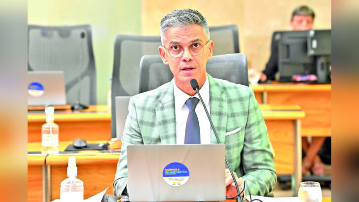Coronel Azevedo, de terno verde e óculos, fala ao microfone sentado à mesa na Assembleia Legislativa do RN