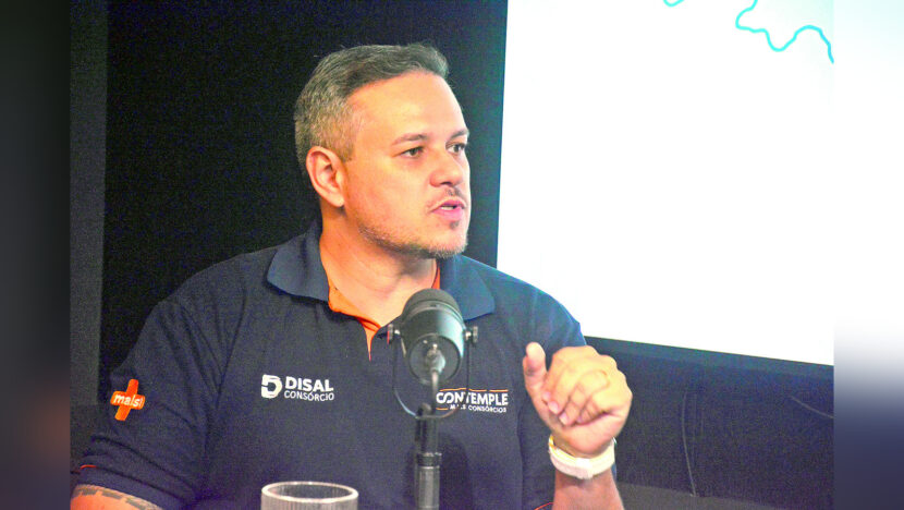 Fernando Leite, de camisa polo preta, fala ao microfone durante entrevista no estúdio do podcast