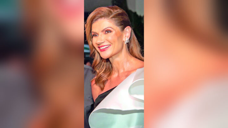 Laurita Arruda, de cabelos ruivos e roupa clara, sorri para fotografia