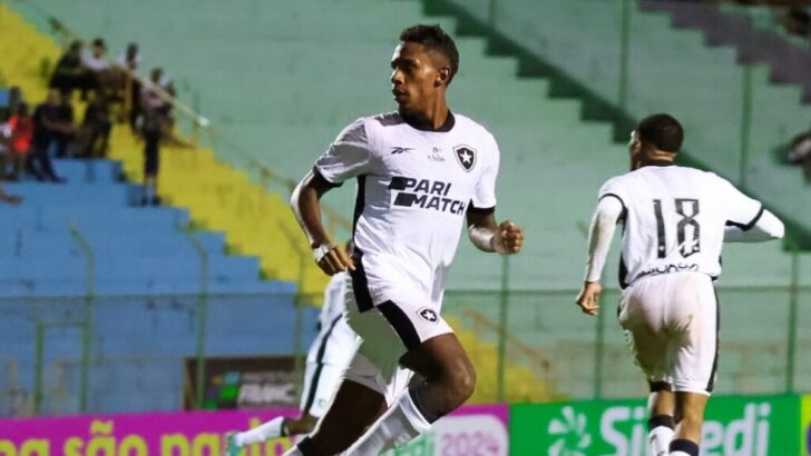 João Guilherme corre em campo com o uniforme branco do Botafogo