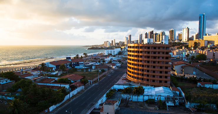 Vista da orla de Natal, com praia, avenida e prédios à beira-mar