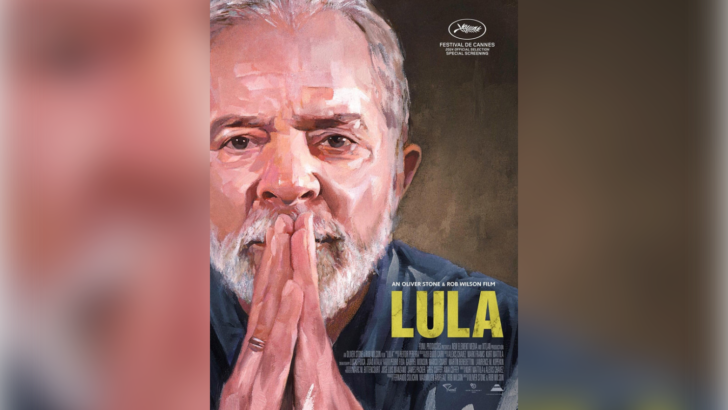 Pôster do documentário Lula com retrato do presidente de mãos unidas diante do rosto e título em letras amarelas
