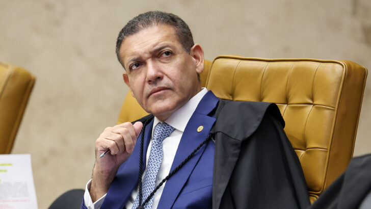 Ministro Kassio Nunes Marques sentado em poltrona no STF