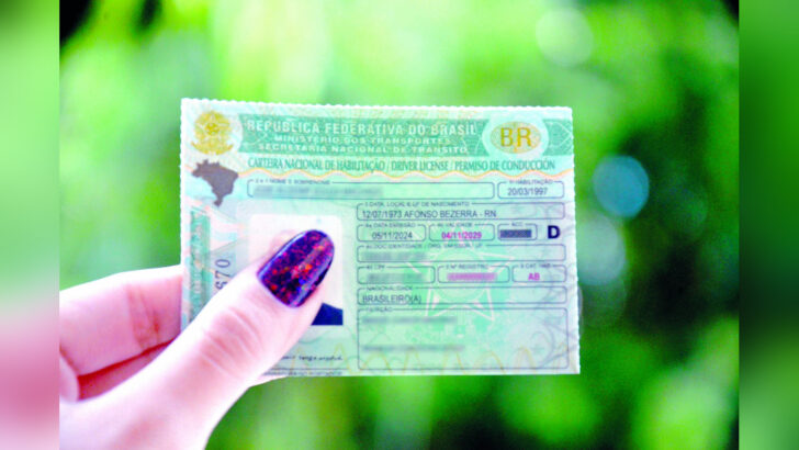 Mão segura uma Carteira Nacional de Habilitação