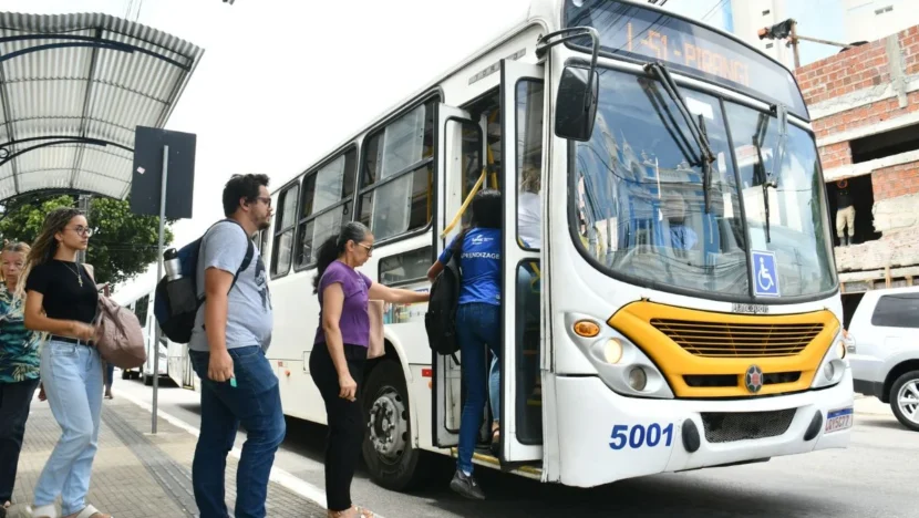 Passageiros ao lado de um ônibus do transporte público em Natal.