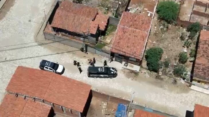 Imagem aérea mostra viaturas e policiais durante ação em área residencial