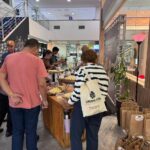 Visitantes observam queijos em mesa de degustação durante evento no Sebrae-RN