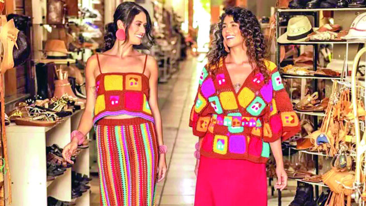 Modelos apresentam peças artesanais coloridas em ambiente de exposição