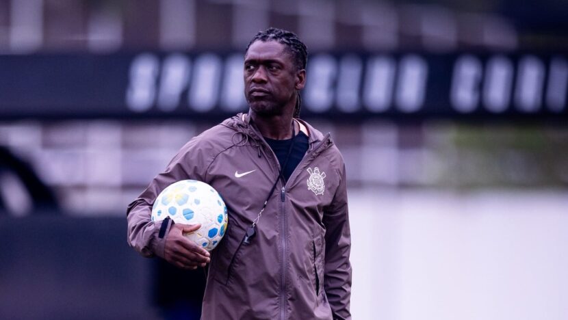 Clarence Seedorf segura uma bola no campo de treino, com agasalho do Corinthians