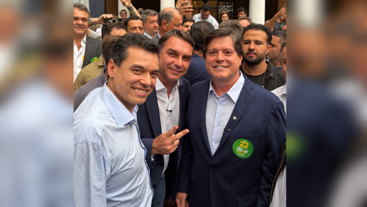 Walter Alves, Flávio Bolsonaro e Baleia Rossi posam juntos em encontro político, em fotografia central com laterais desfocadas
